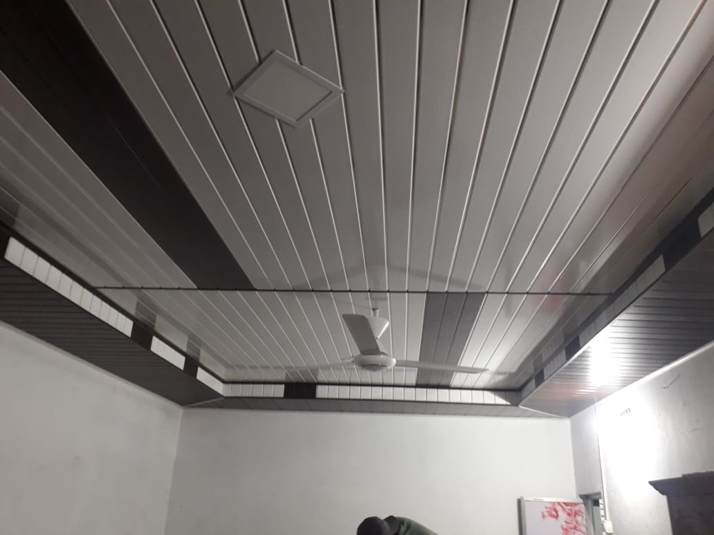 Layered white and wood ceiling with blue recessed lights
