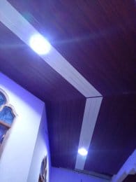 Close view of a wood and white false ceiling with spotlights